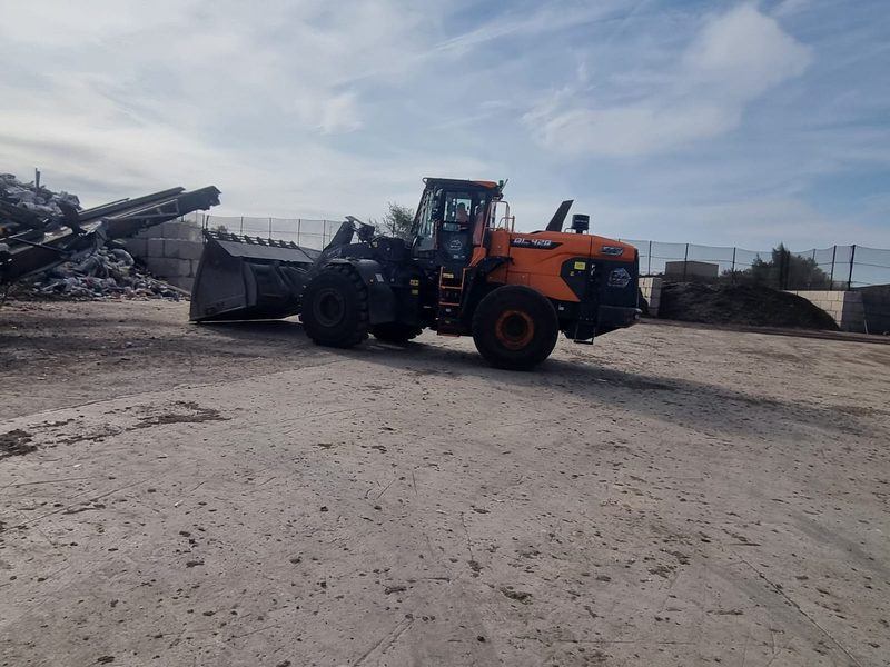 Loading shovel moving recovered material for reuse