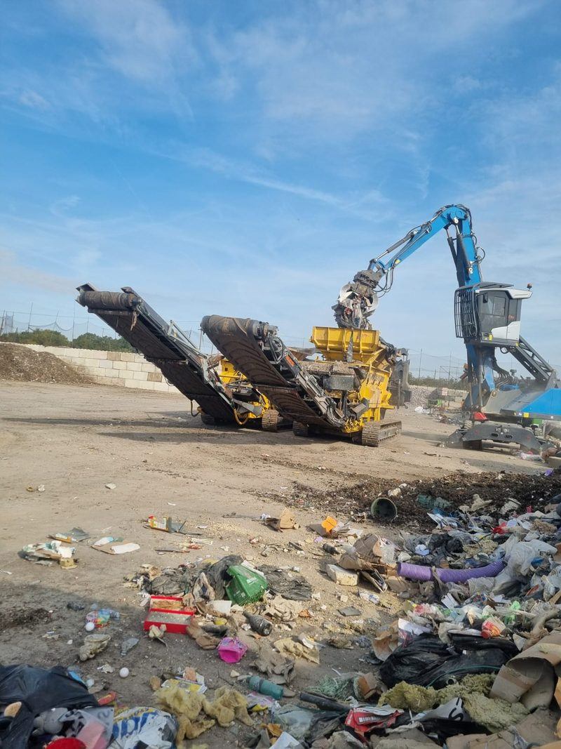 Material handler feeding a mobile shredder with mixed waste