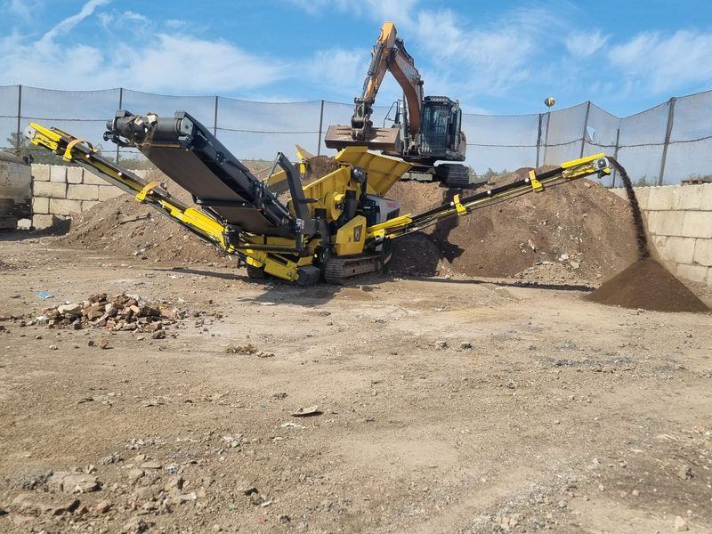 Screened soil stockpiles alongside an excavator and screening plant